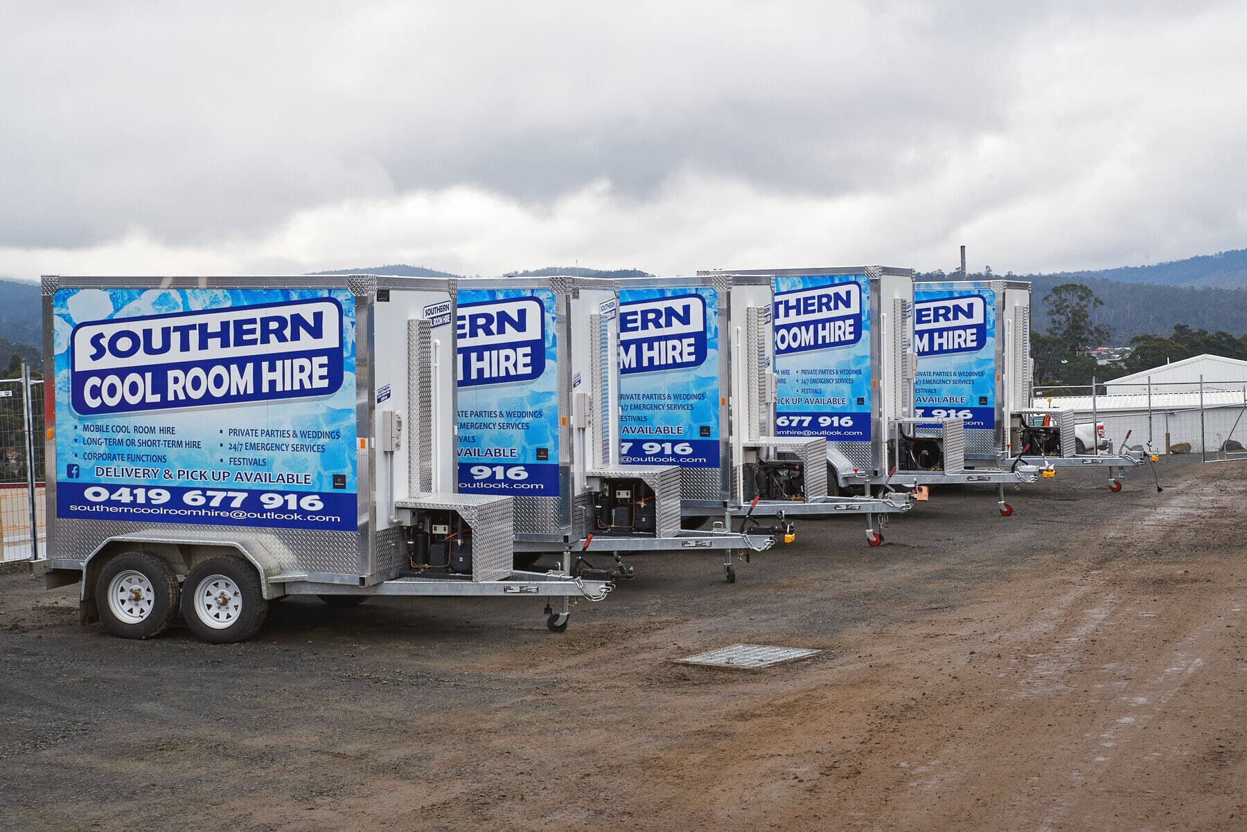 A line of Southern Cool Room Hire trailers parked in the yard